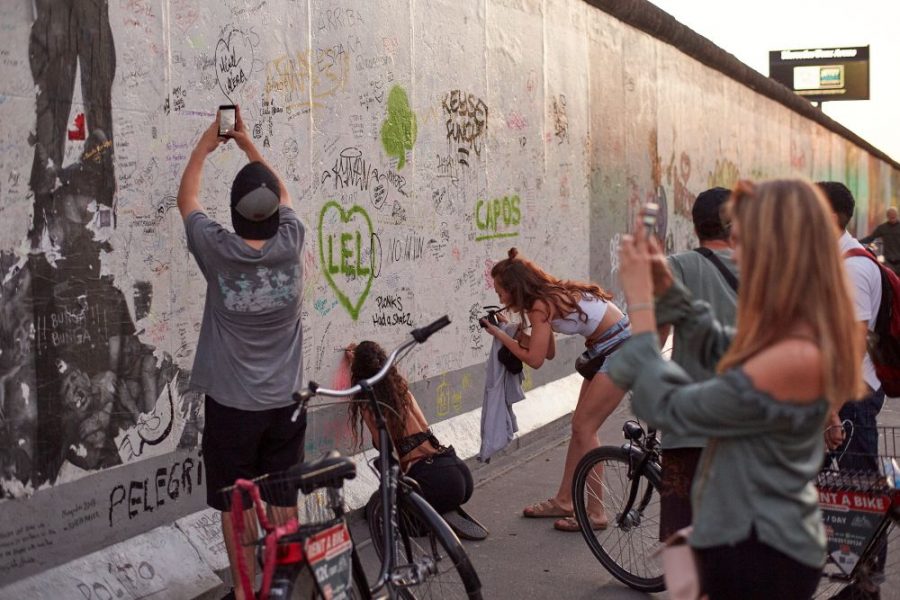 Personen malen und fotografieren die East Side Gallery