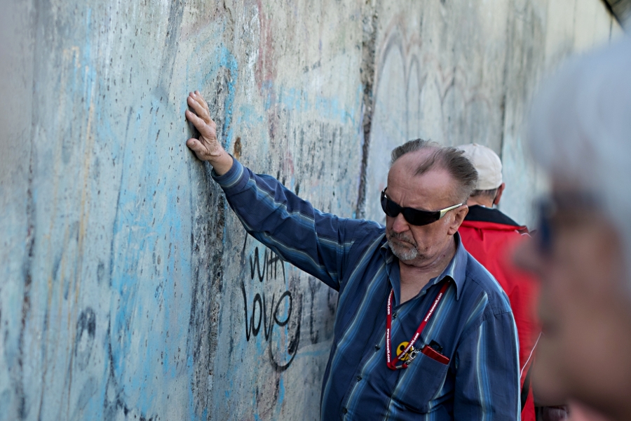 Besucher betatstet die Berliner Mauer