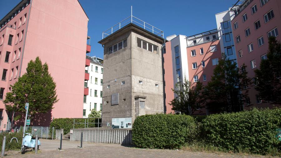 Ein alter DDR-Wachturm inmitten von Wohnhäusern