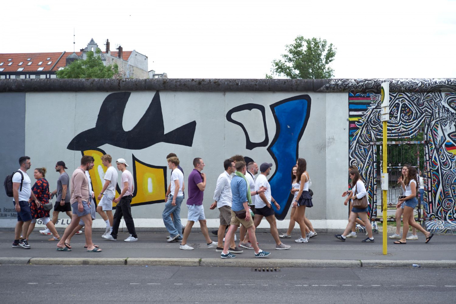Personen laufen an der East Side Gallery entlang