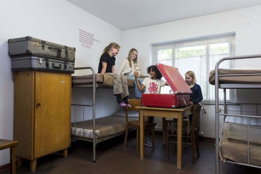 Kinder sind in einem Raum und gucken in einen großen Koffer