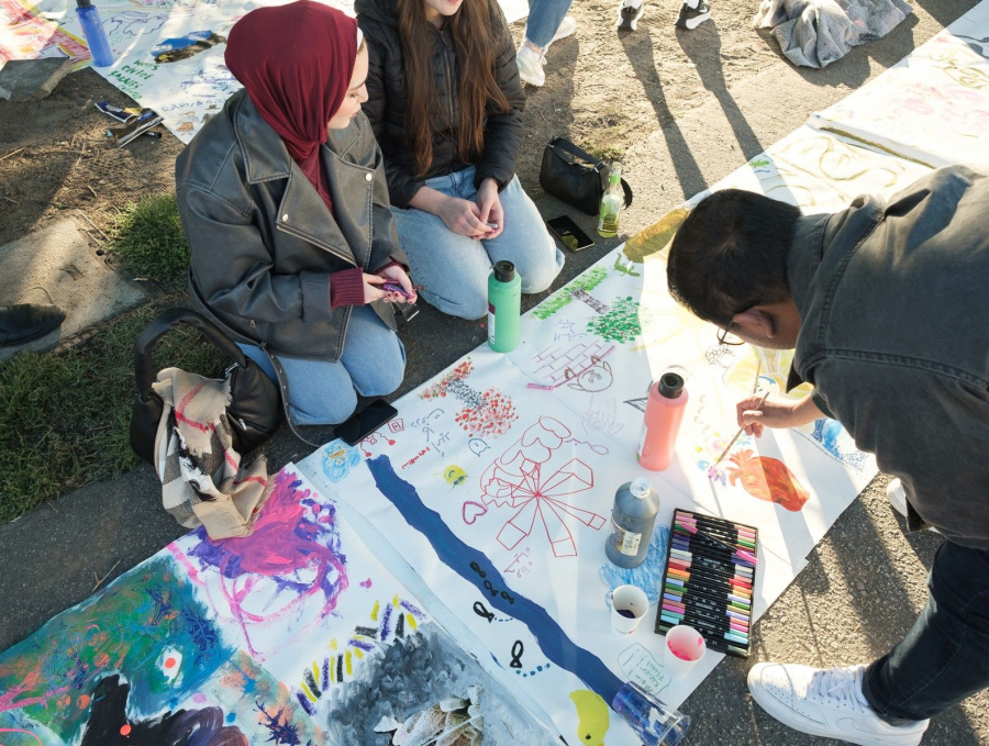 Jugendliche malen auf ein Banner