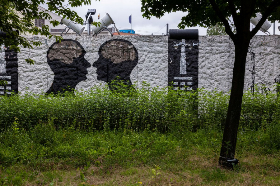 Foto vom Parlament der Bäume: Eine Mauer mit Bild und Wiese ist zu sehen