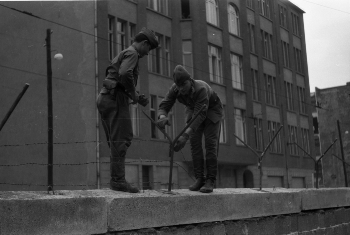 Zwei Soldaten bauen einen Stacheldraht auf