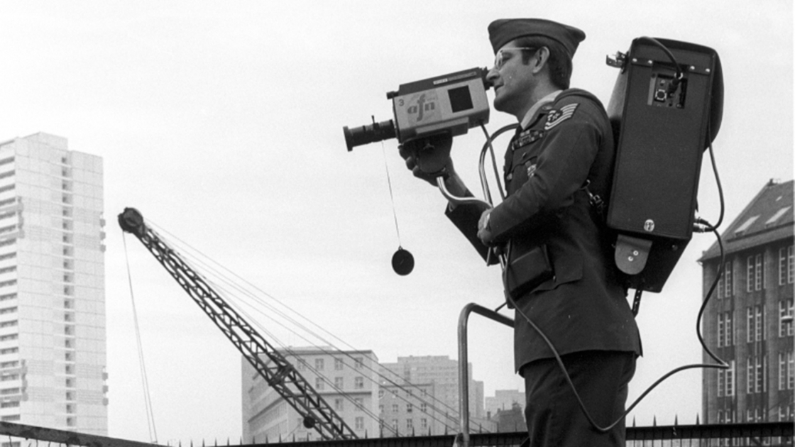 A cameraman on a ladder