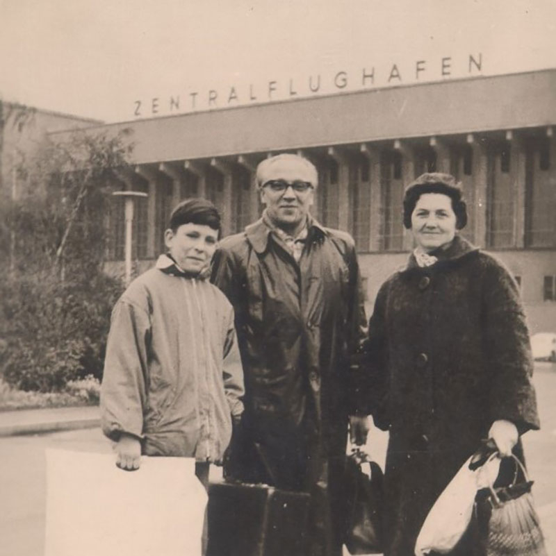 3 Personen stehen mit Koffern vor dem Zentralflughafen