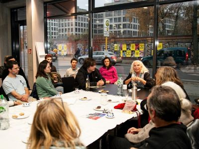 Personen sitzen an einem Tisch und sprechen miteinander