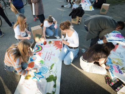 Jugendliche malen auf ein Banner