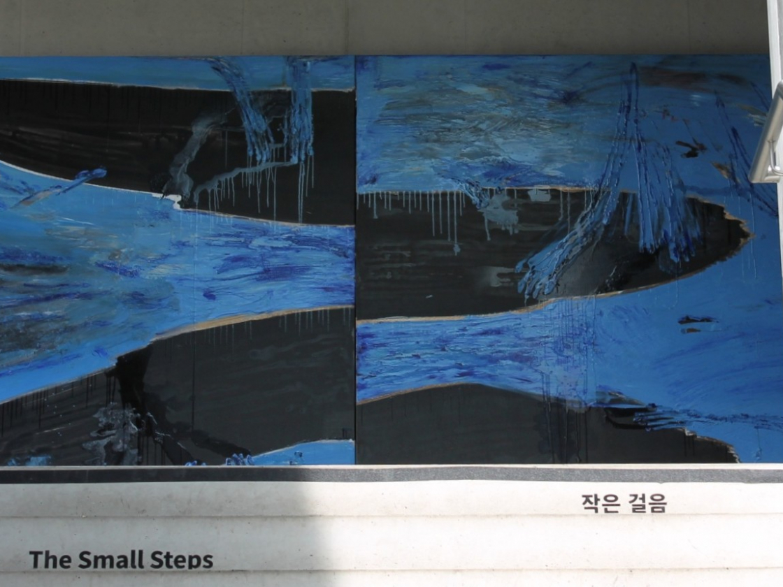 Foto von einem Gemälde der Ausstellung in blau und schwarz
