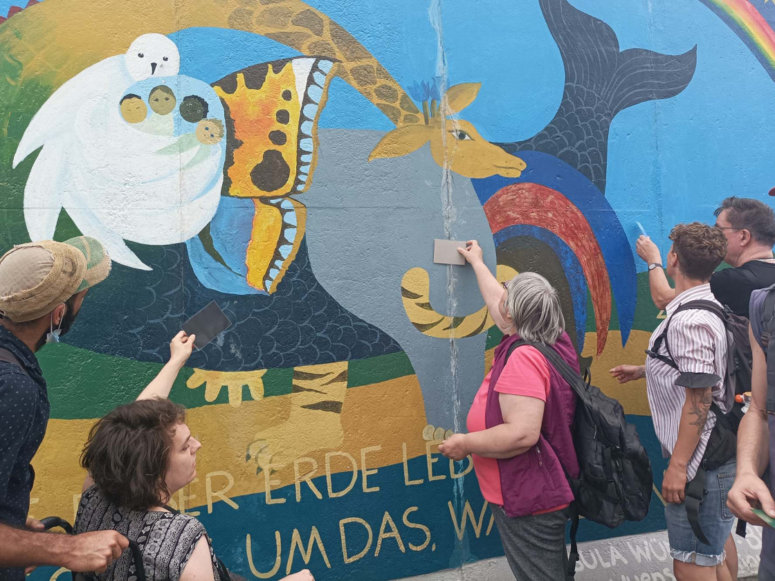 Teilnehmende am Bild von Ursula Wünsch, Frieden für Alles, East Side Gallery, 2022, Stiftung Berliner Mauer