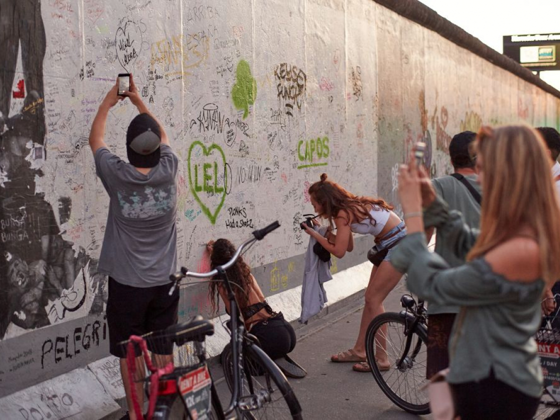 Personen malen und fotografieren die East Side Gallery