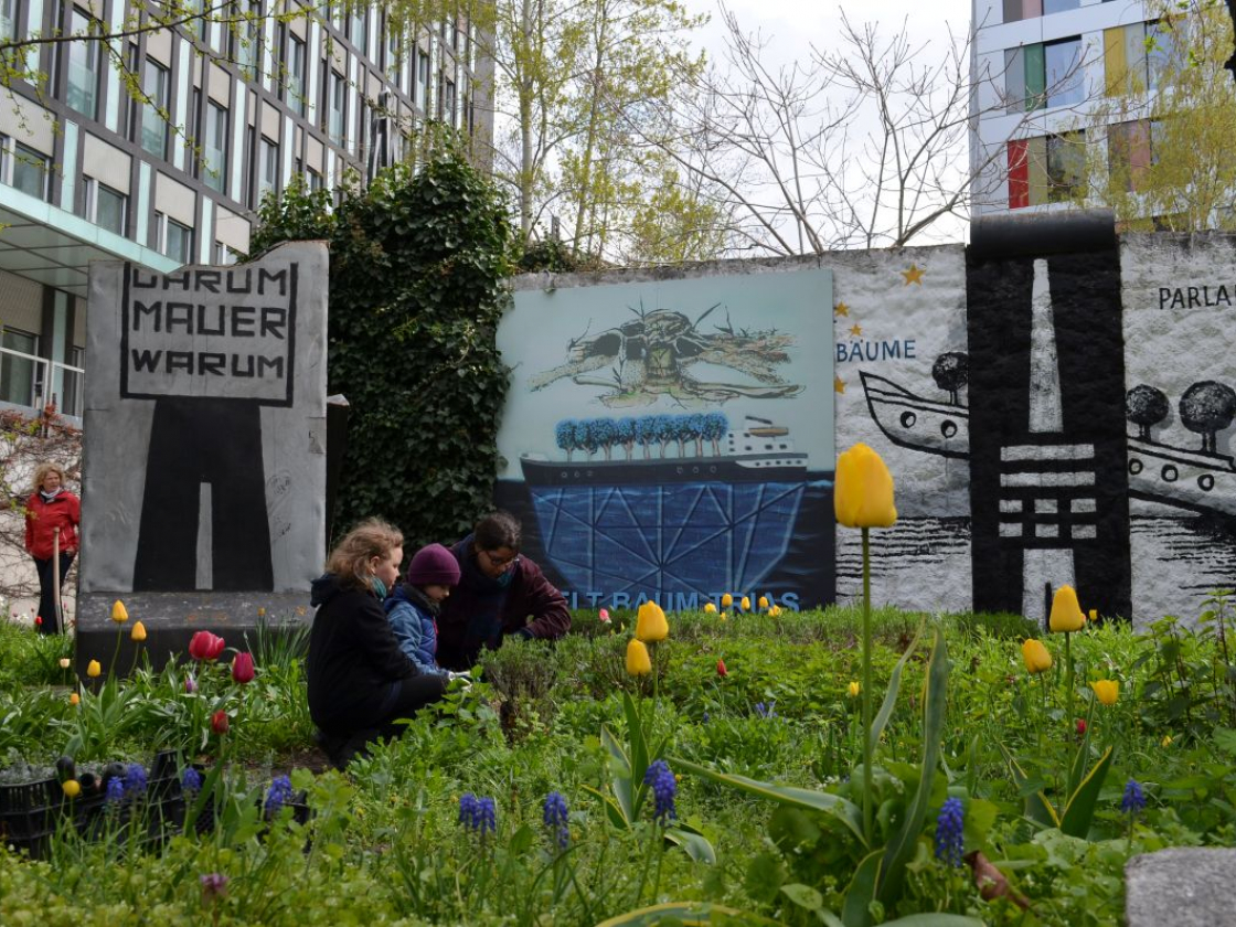 Kinder in einem Garten mit Mauerteilen