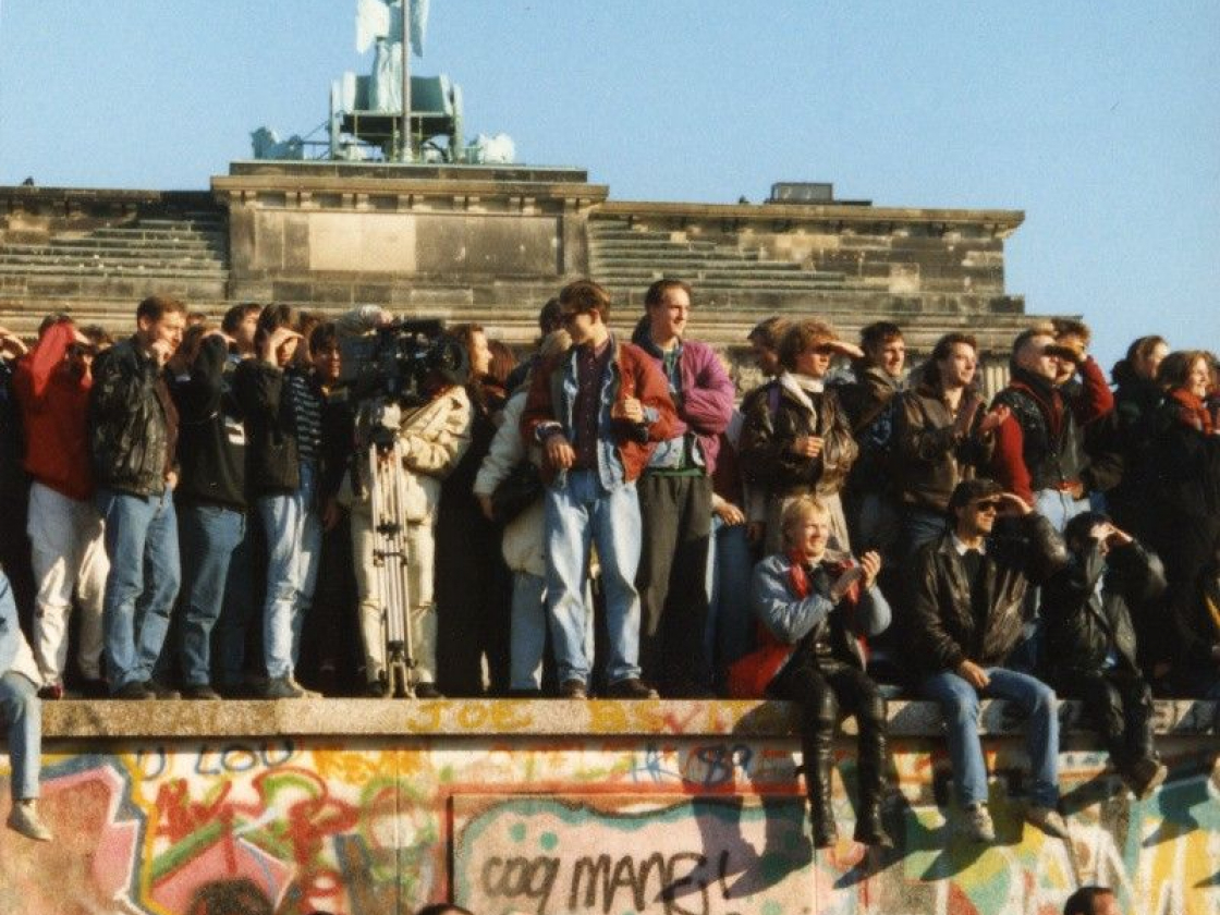 Personen auf der Mauer vor dem Brandenburger Tor am Tag nach dem Mauerfall