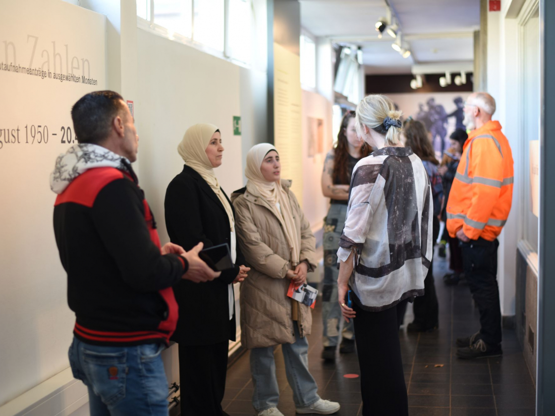 Personen und Guide in der Ausstellung "Flucht im geteilten Deutschland"