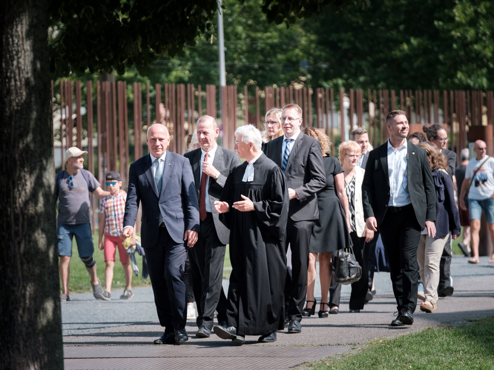 Gäste laufen auf einem Weg zum Denkmal