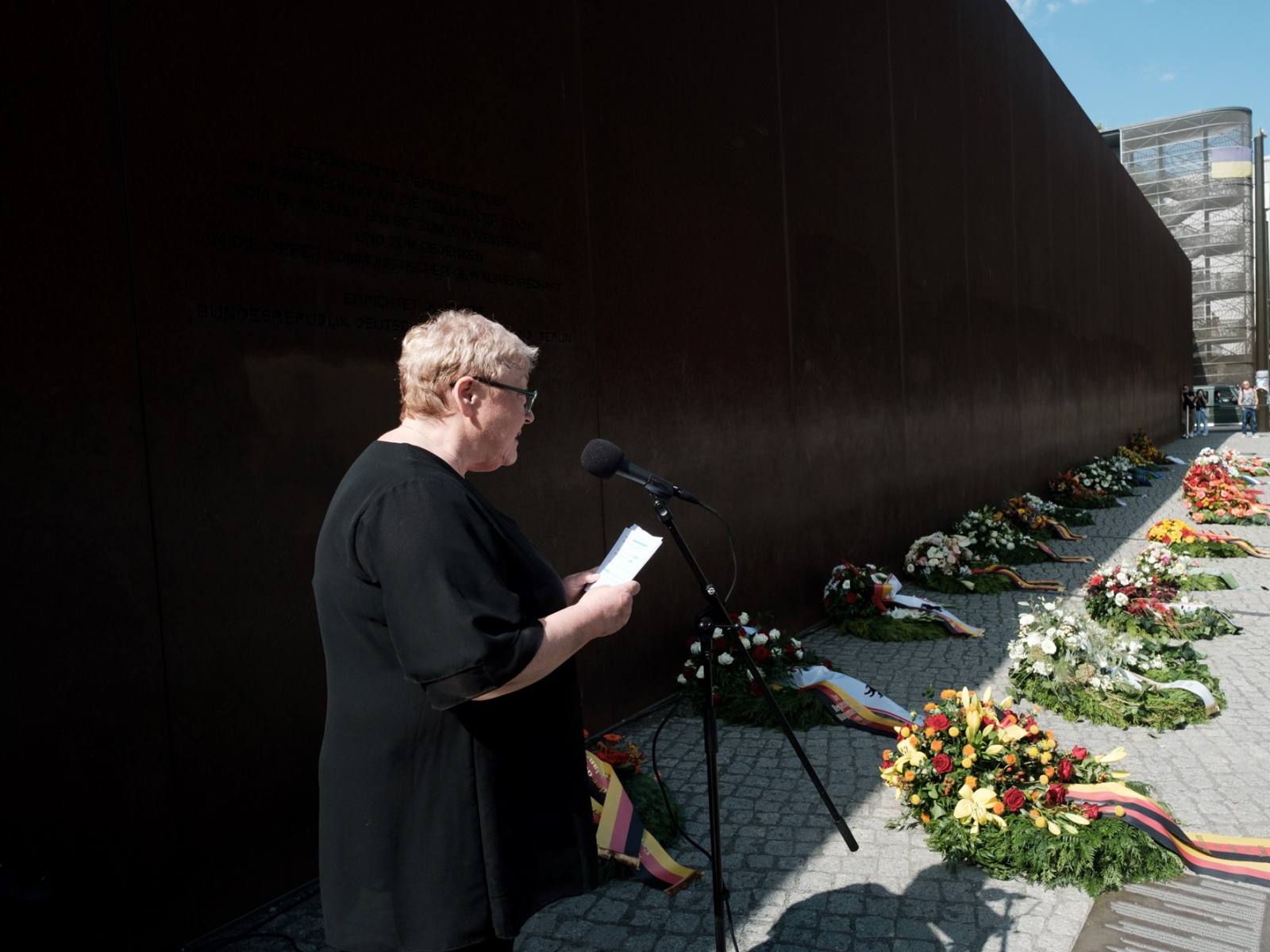 Person spricht draußen am Denkmal