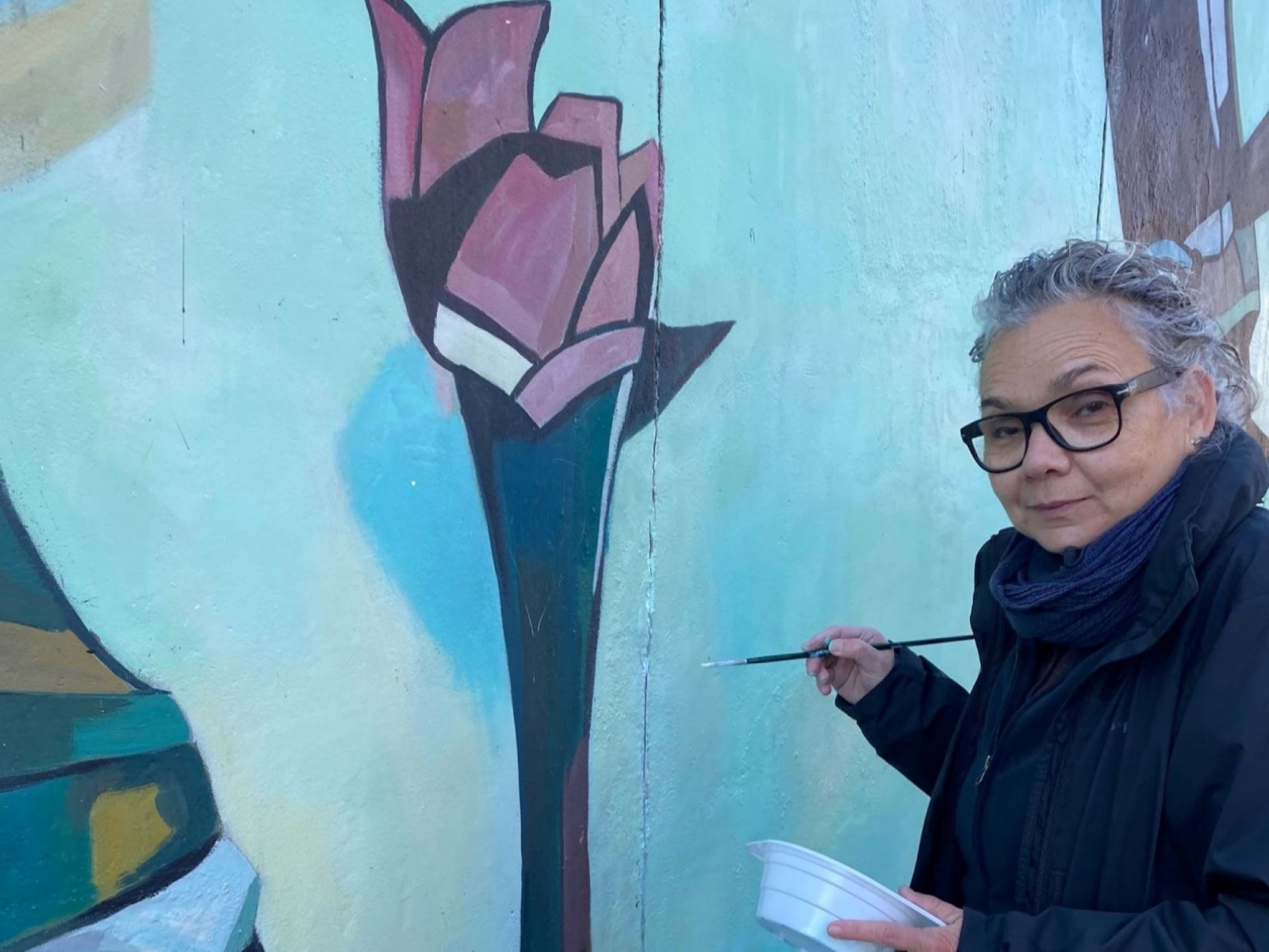 Teresa Casanueva bessert ihr Bild an der East Side Gallery aus